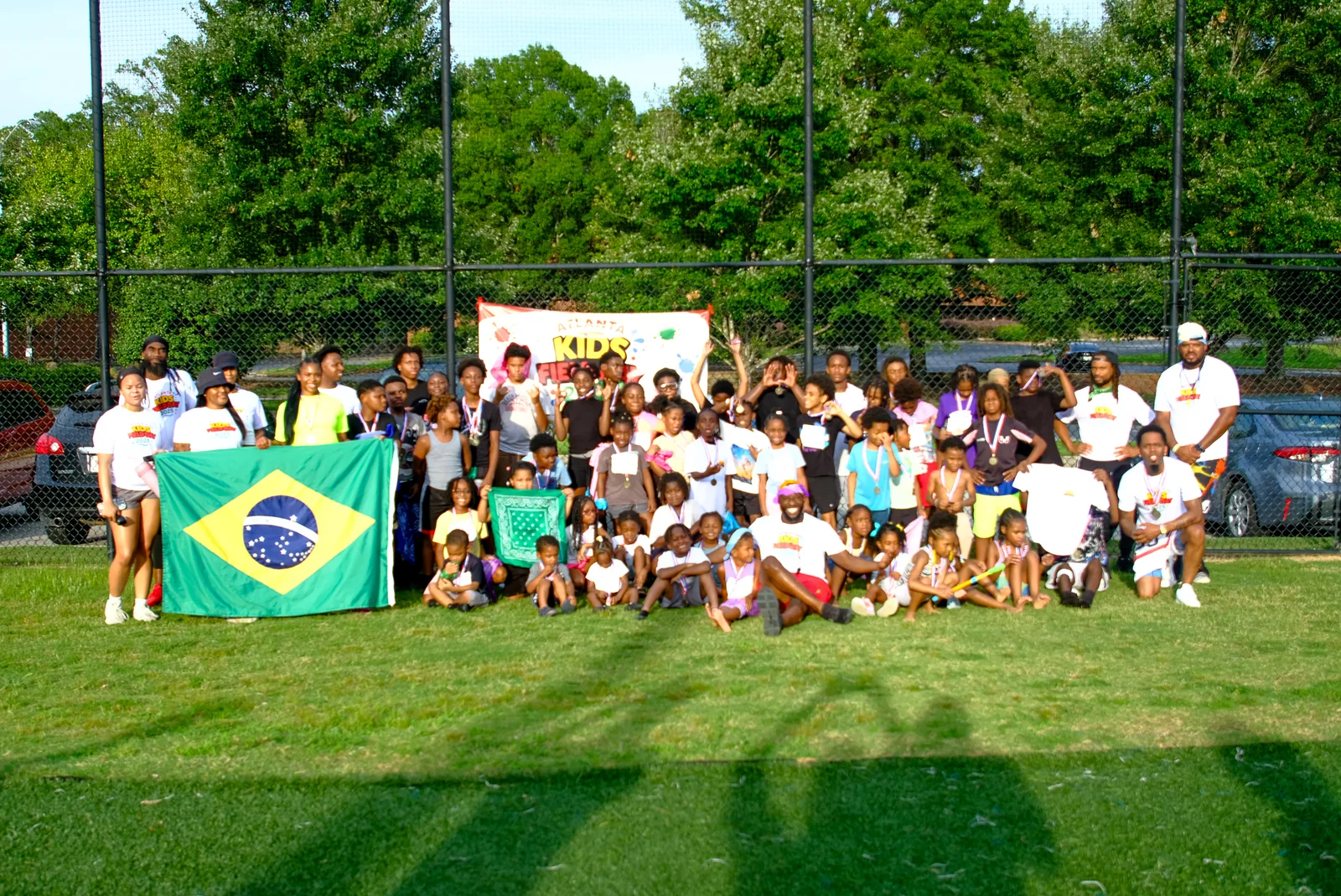 Faith First Fitness coaches and kids celebrating together at a field day